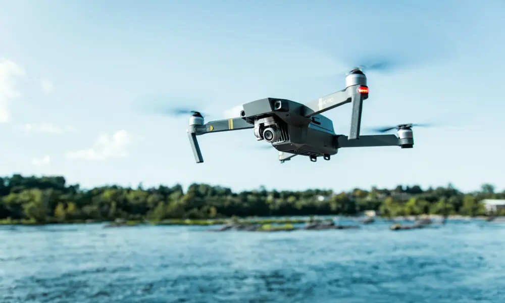 black DJI Mavi quadcopter near body of water