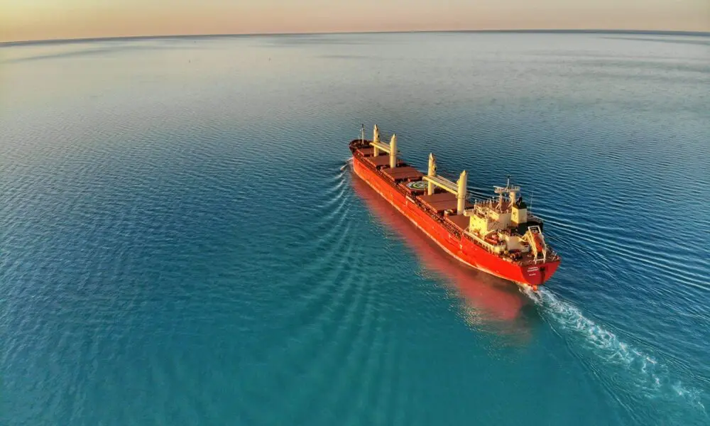red and white cargo ship at middle of ocean