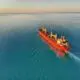 red and white cargo ship at middle of ocean