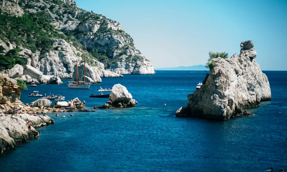 a body of water with boats and rocky cliffs