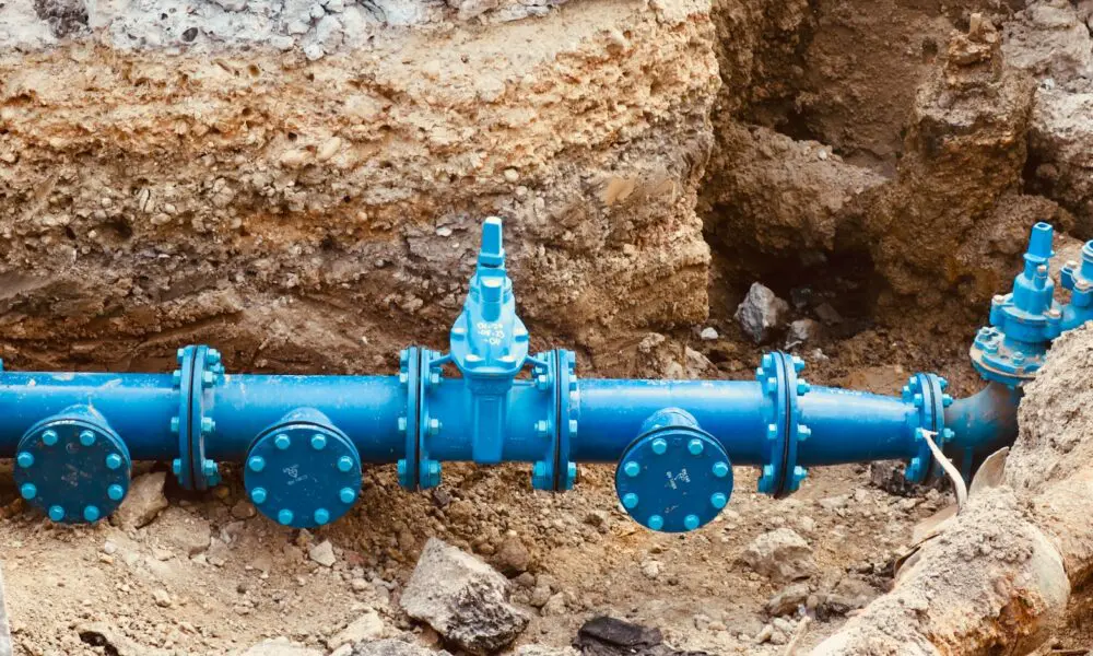 a blue pipe laying on top of a pile of dirt
