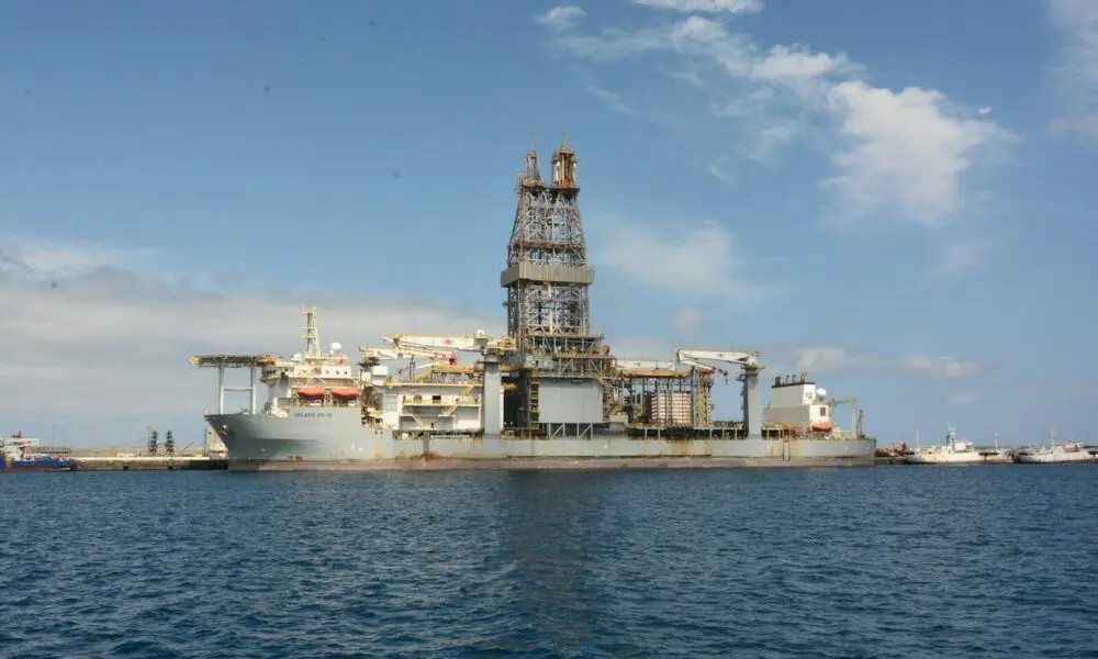 A large oil rig is docked in the ocean.