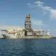 A large oil rig is docked in the ocean.