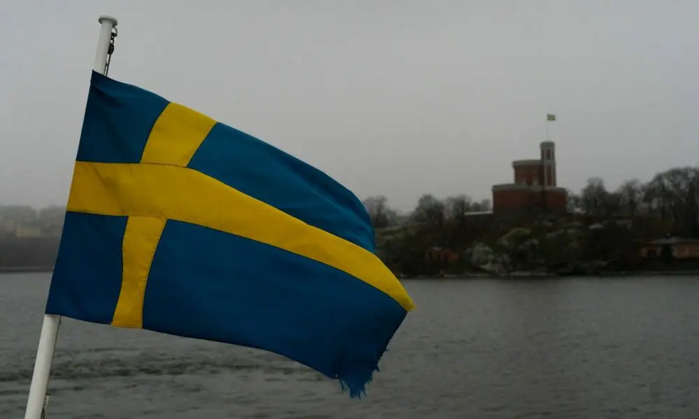 a blue and yellow flag flying over a body of water