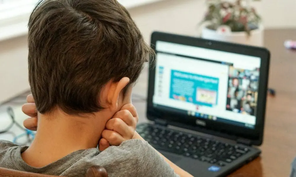 boy in gray shirt using black laptop computer