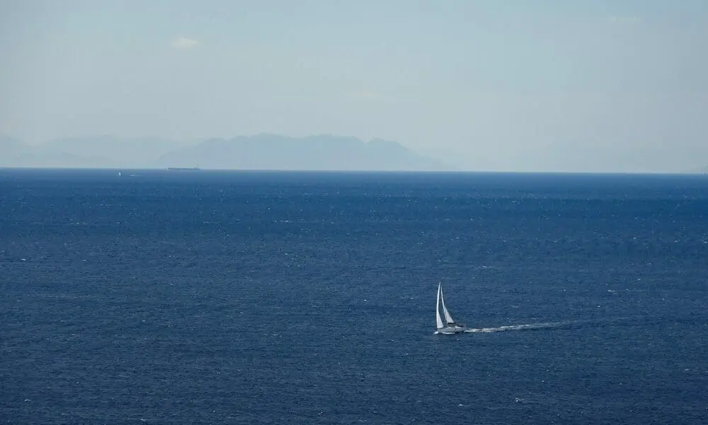 a sailboat in the middle of the ocean