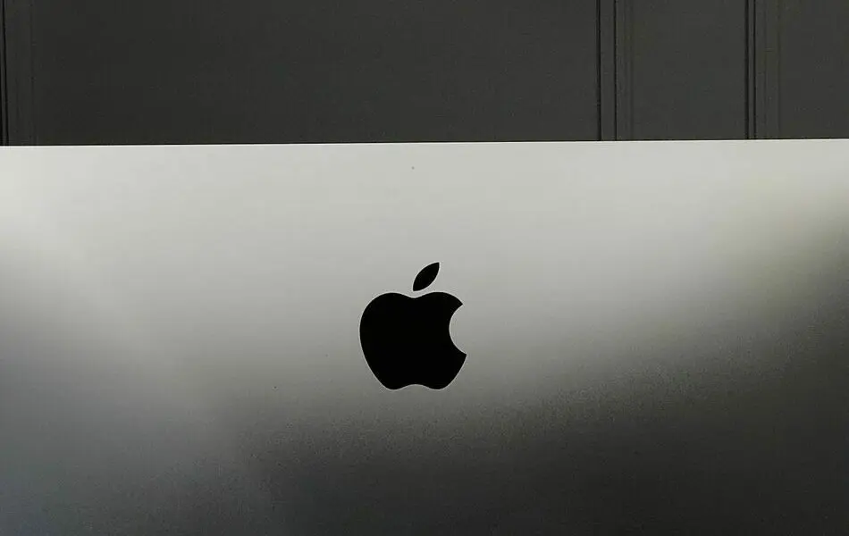 Close-up of an Apple iMac in a minimalist setup, showcasing its sleek design and elegant branding.