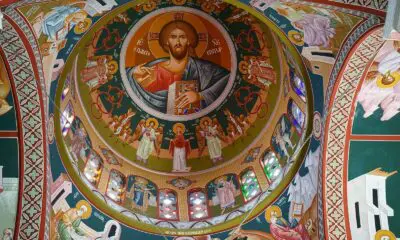 A painting of jesus on the ceiling of a church
