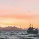 white sailboat in body of water during sunset