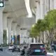 Cars driving under elevated highway in Shanghai, China during daytime.