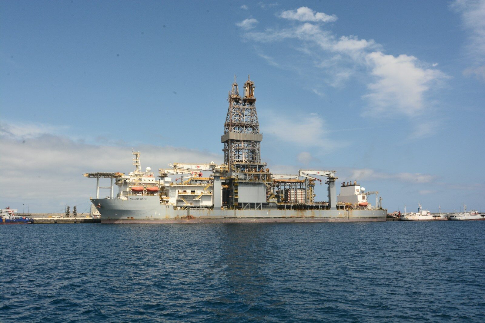 A large oil rig is docked in the ocean.