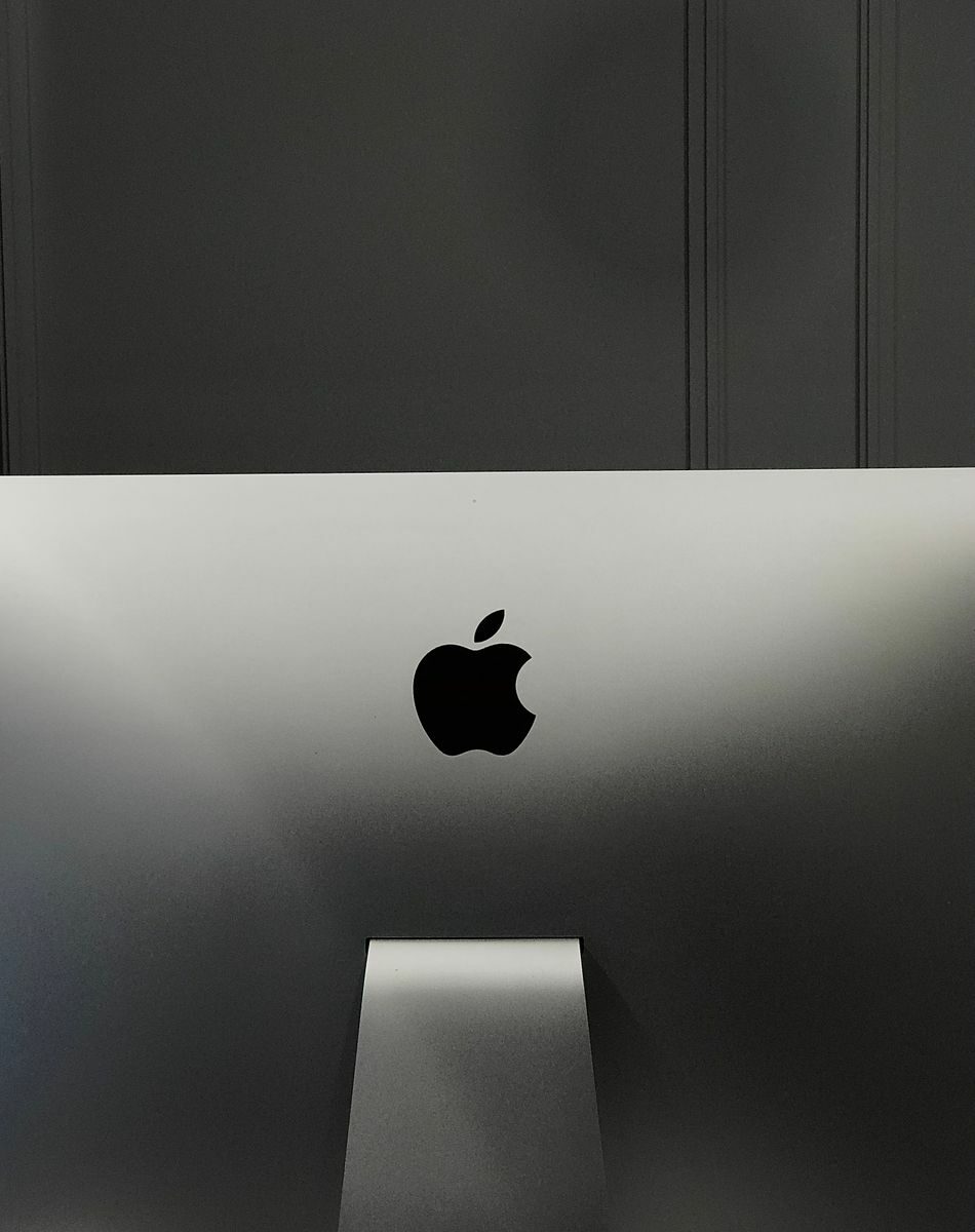 Close-up of an Apple iMac in a minimalist setup, showcasing its sleek design and elegant branding.